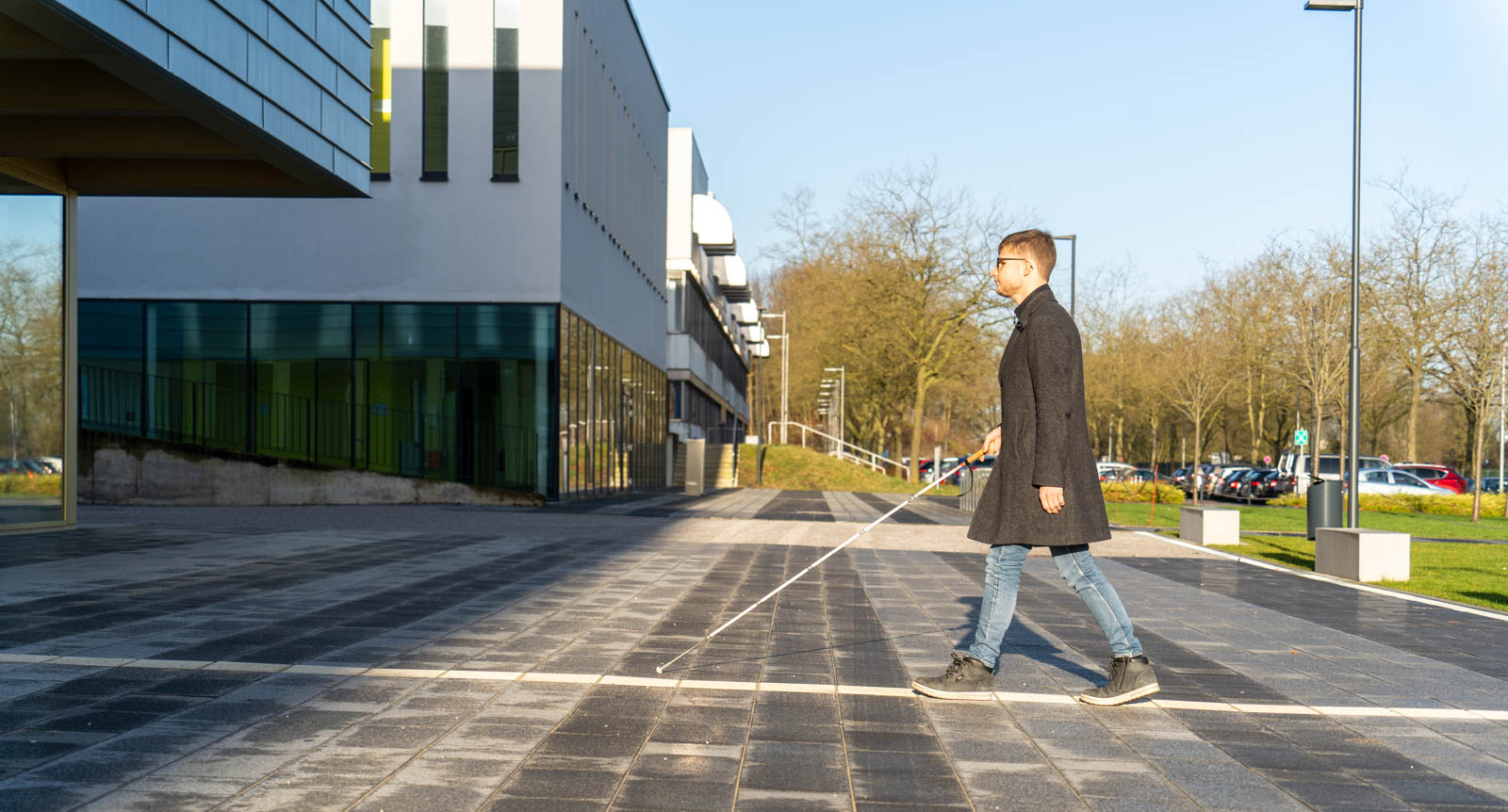 Person mit Langstock auf Leitsystem